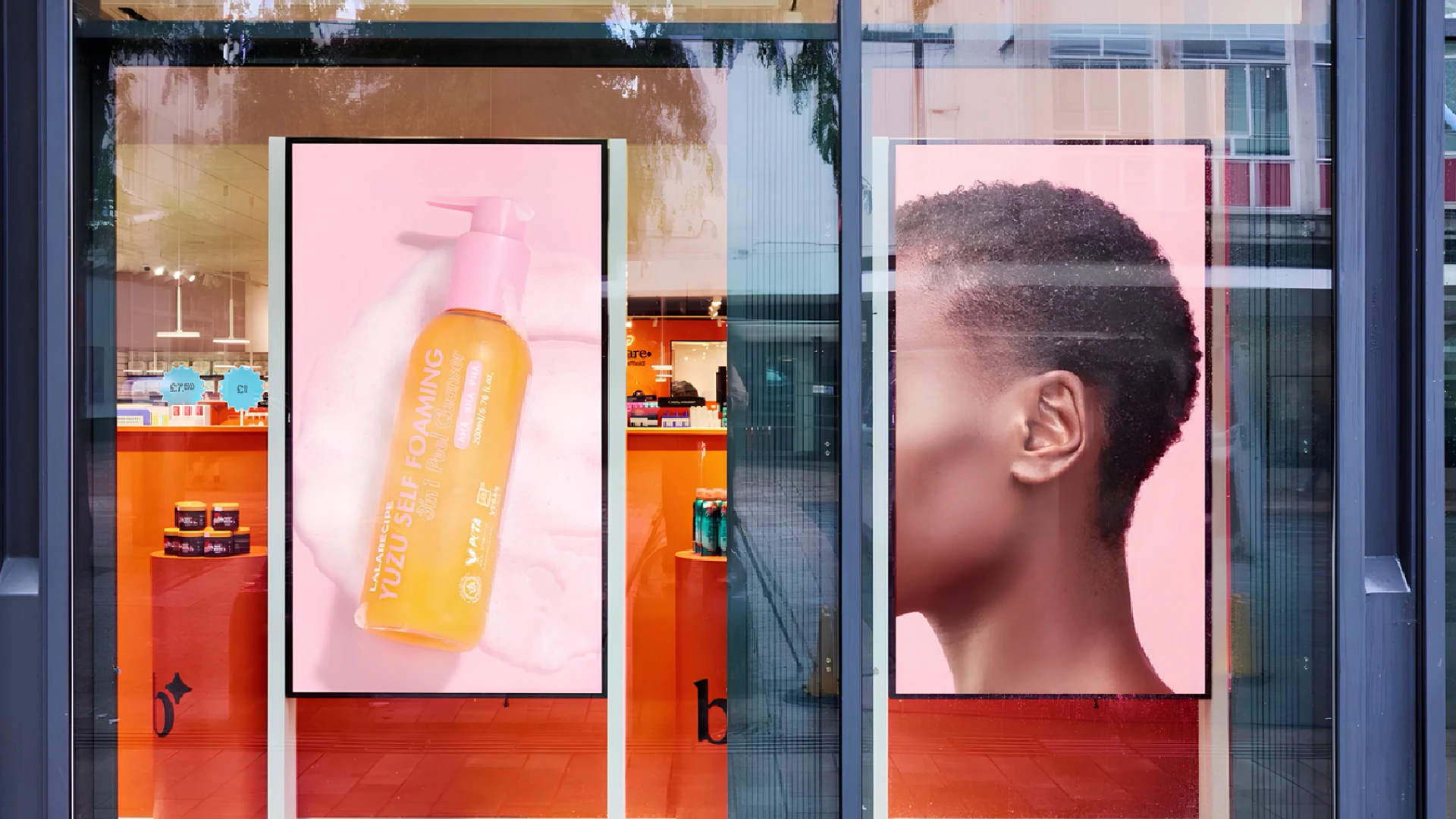 Bodycare retail window with digital beauty advertising showing haircare product imagery and a model as part of the brand’s relaunch.
