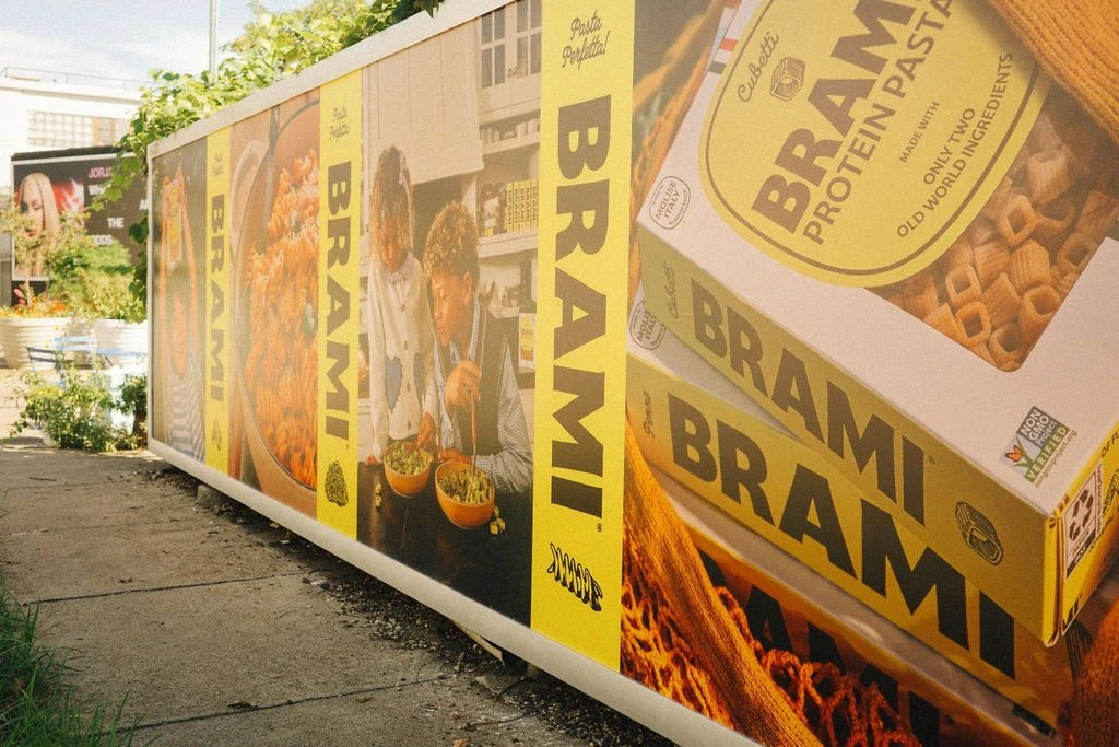 Brami protein pasta outdoor wall advertising in New York featuring product packs and Pasta Perfetta branding.