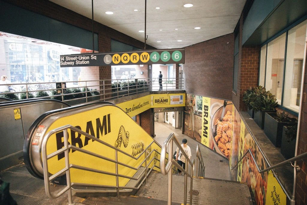 Brami yellow OOH takeover inside 14 Street Union Square subway station in New York.