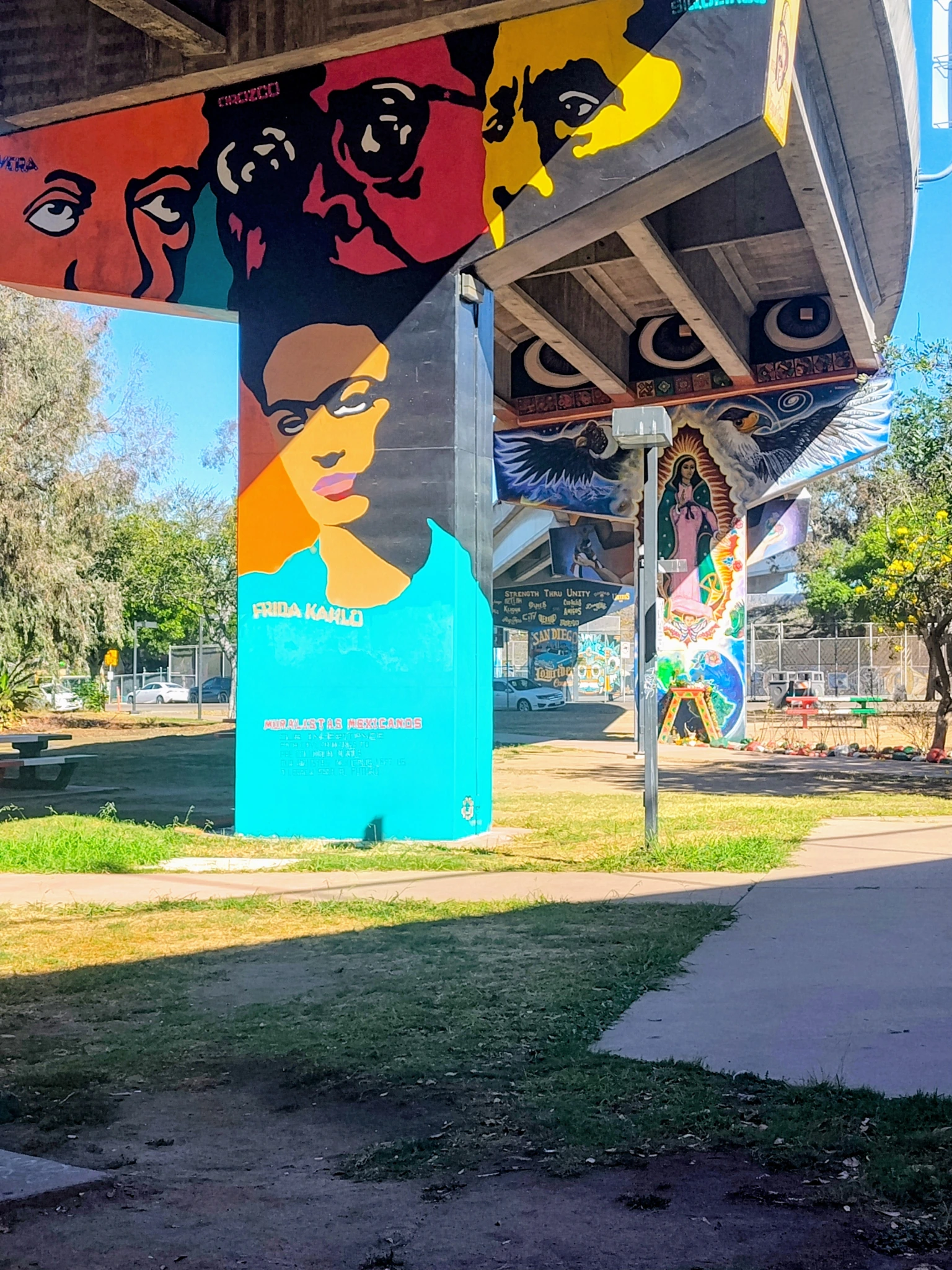 Colorful Chicano Park murals including a Frida Kahlo portrait painted on freeway columns.
