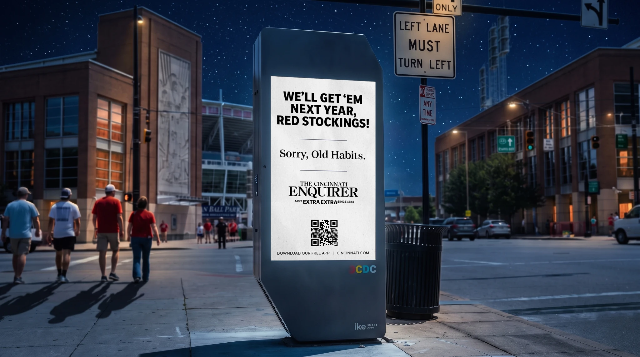 Cincinnati Enquirer digital street kiosk near a stadium displaying the line We’ll get ’em next year, Red Stockings! as part of the A Bit Extra Extra Since 1841 campaign.