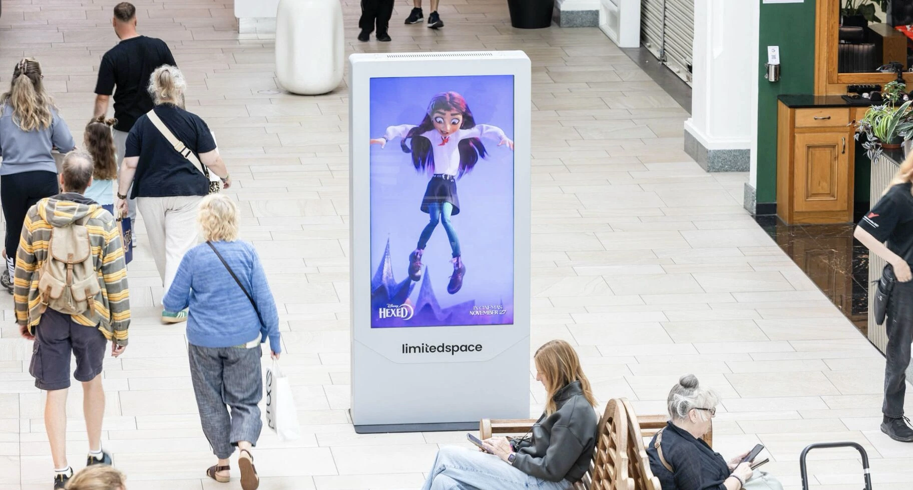 Full-body Disney Hexed character creative shown on a D6 digital screen in a shopping centre atrium.