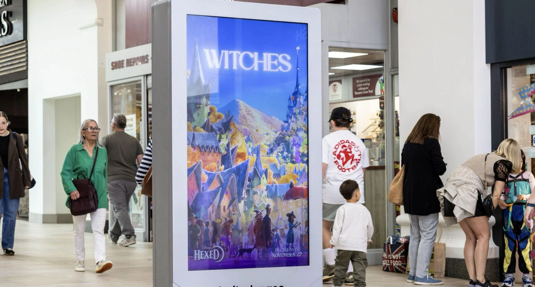 Disney Hexed poster with the word Witches displayed on a D6 digital screen in a shopping centre.