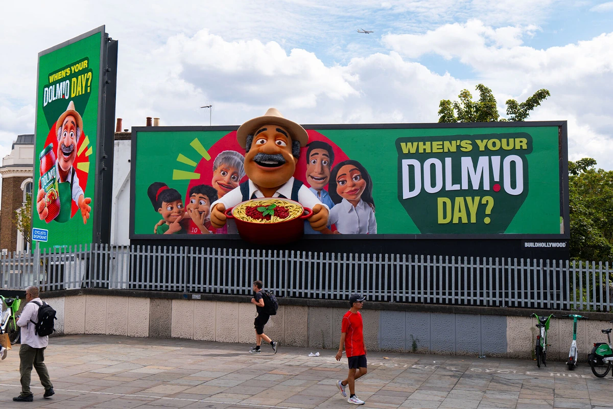 Dolmio 96-sheet special-build billboard in Shepherd’s Bush featuring the puppet family and a 3D Papa holding bolognese.