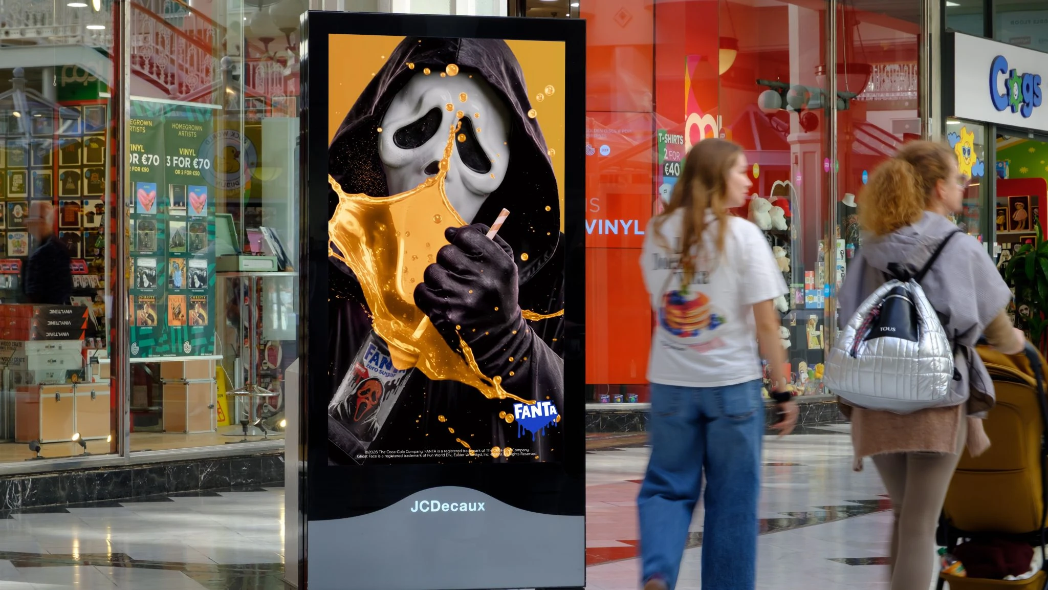 Fanta Halloween DOOH campaign featuring a masked horror character and orange soda splash on a digital retail screen.