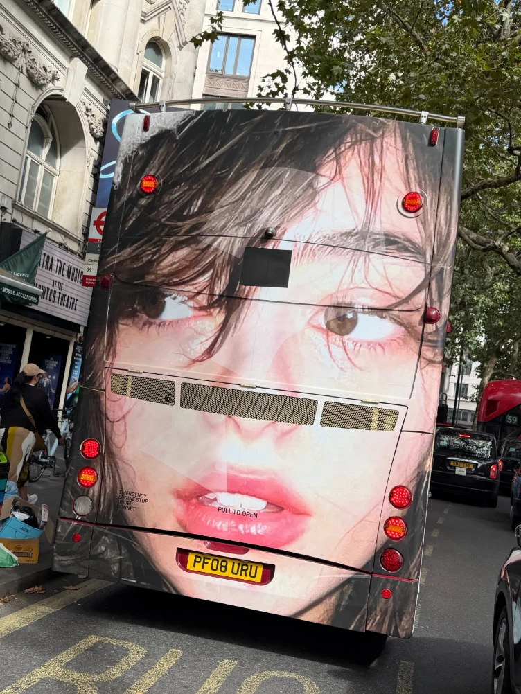 Rear close-up portrait on a Guess Girls wrapped double-decker bus driving through London.