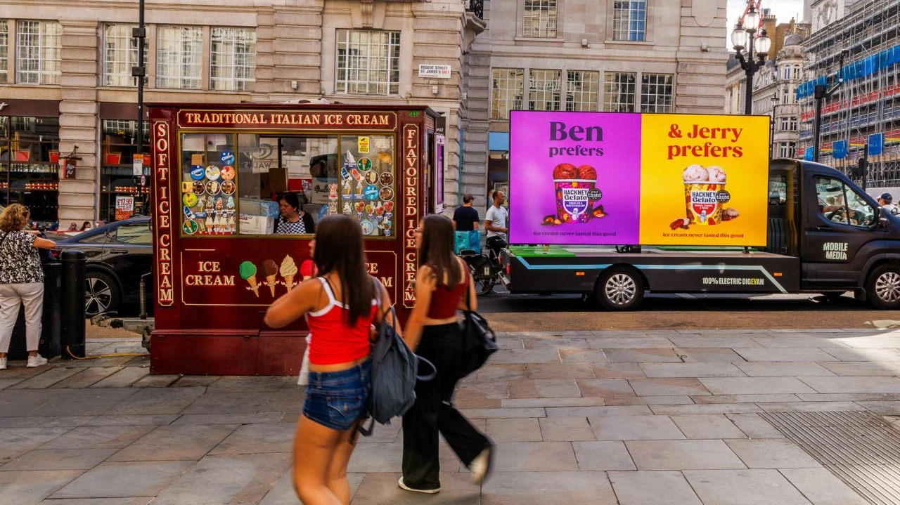 Hackney Gelato mobile LED advertising truck parked beside a traditional ice cream kiosk in London.