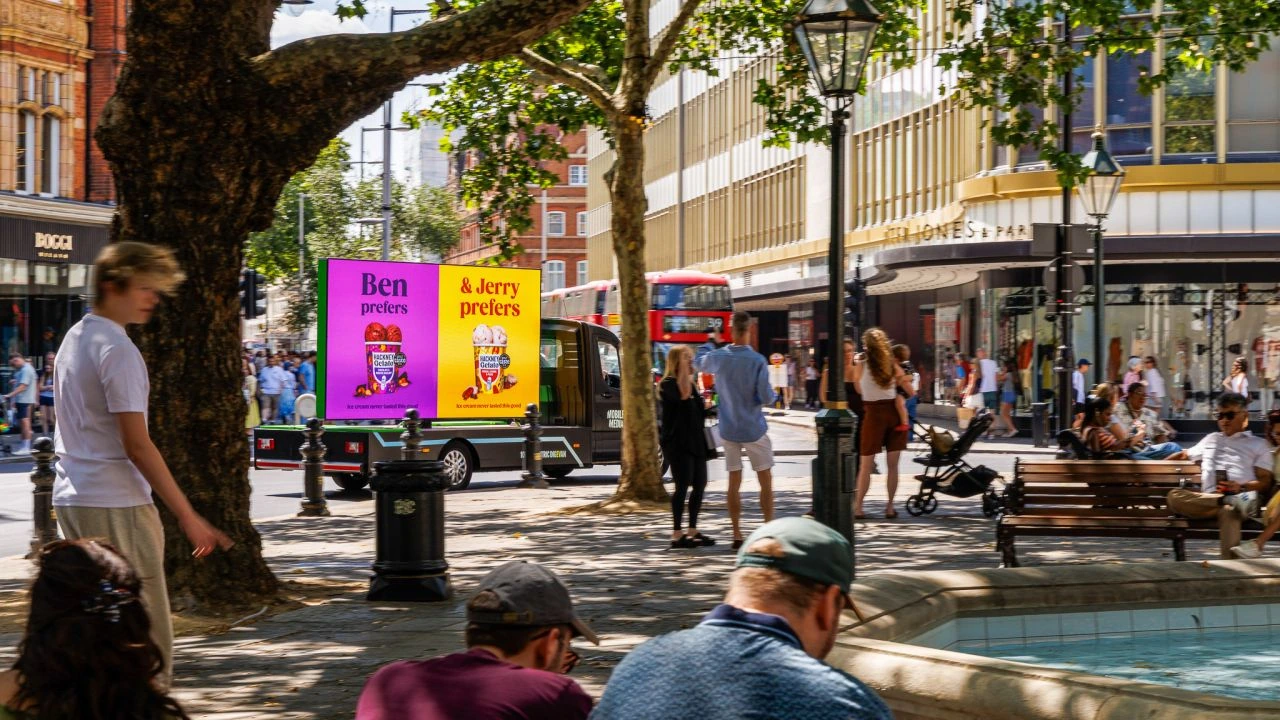 Hackney Gelato mobile OOH screen driving visibility in a busy London public space with pedestrians and seating nearby.