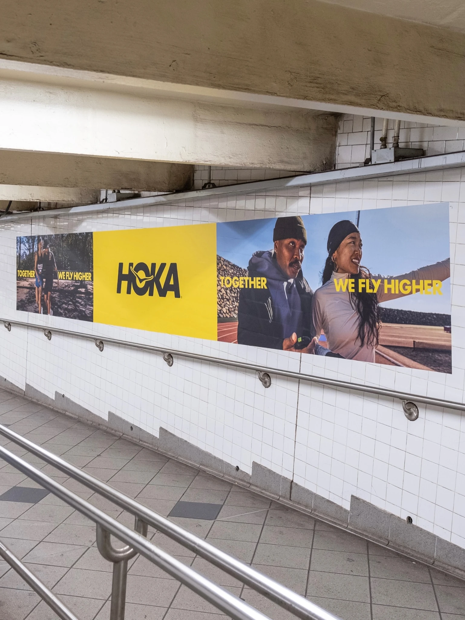 HOKA Columbus Circle station domination featuring Together We Fly Higher transit advertising across subway walls.