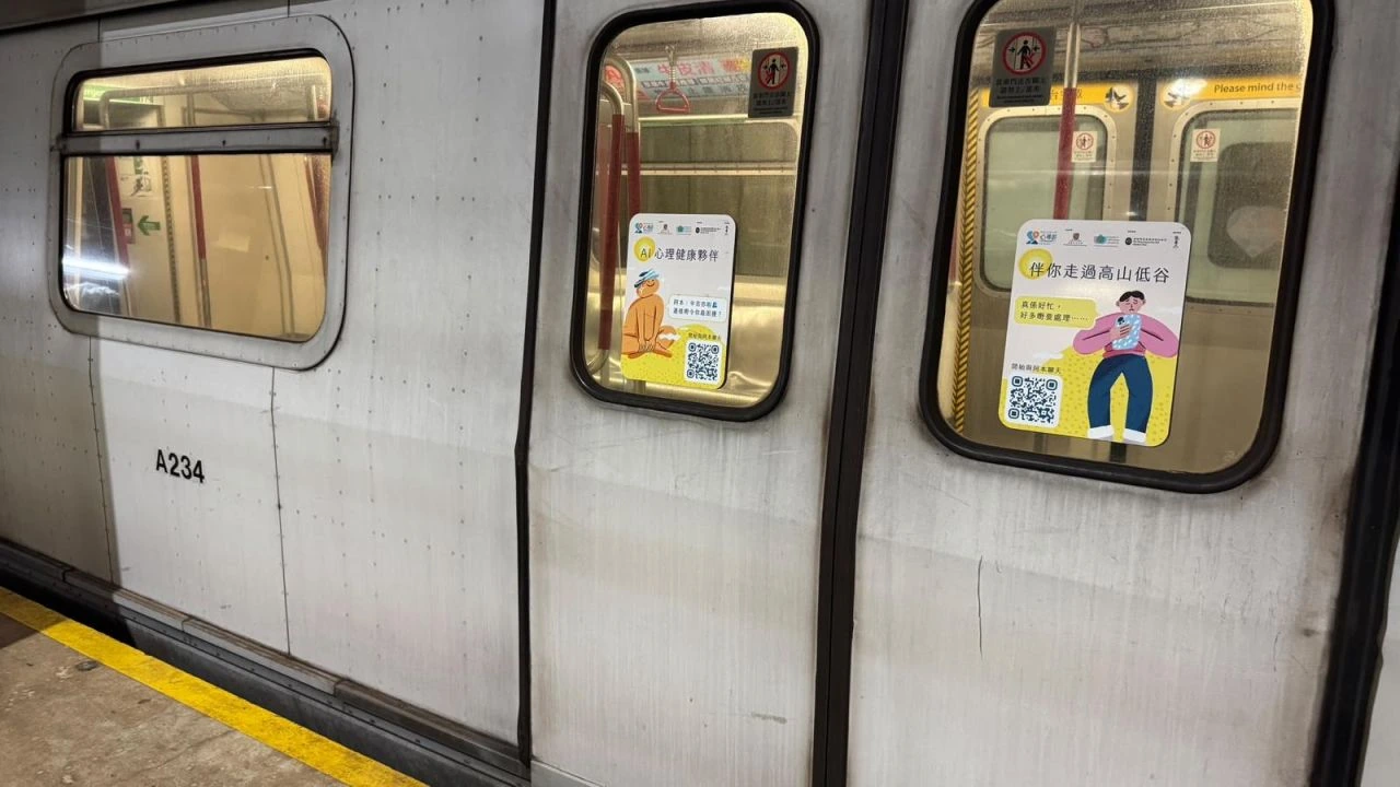 Hong Kong MTR carriage with Jockey Club TourHeart+ mental health stickers visible on the train windows from the platform.