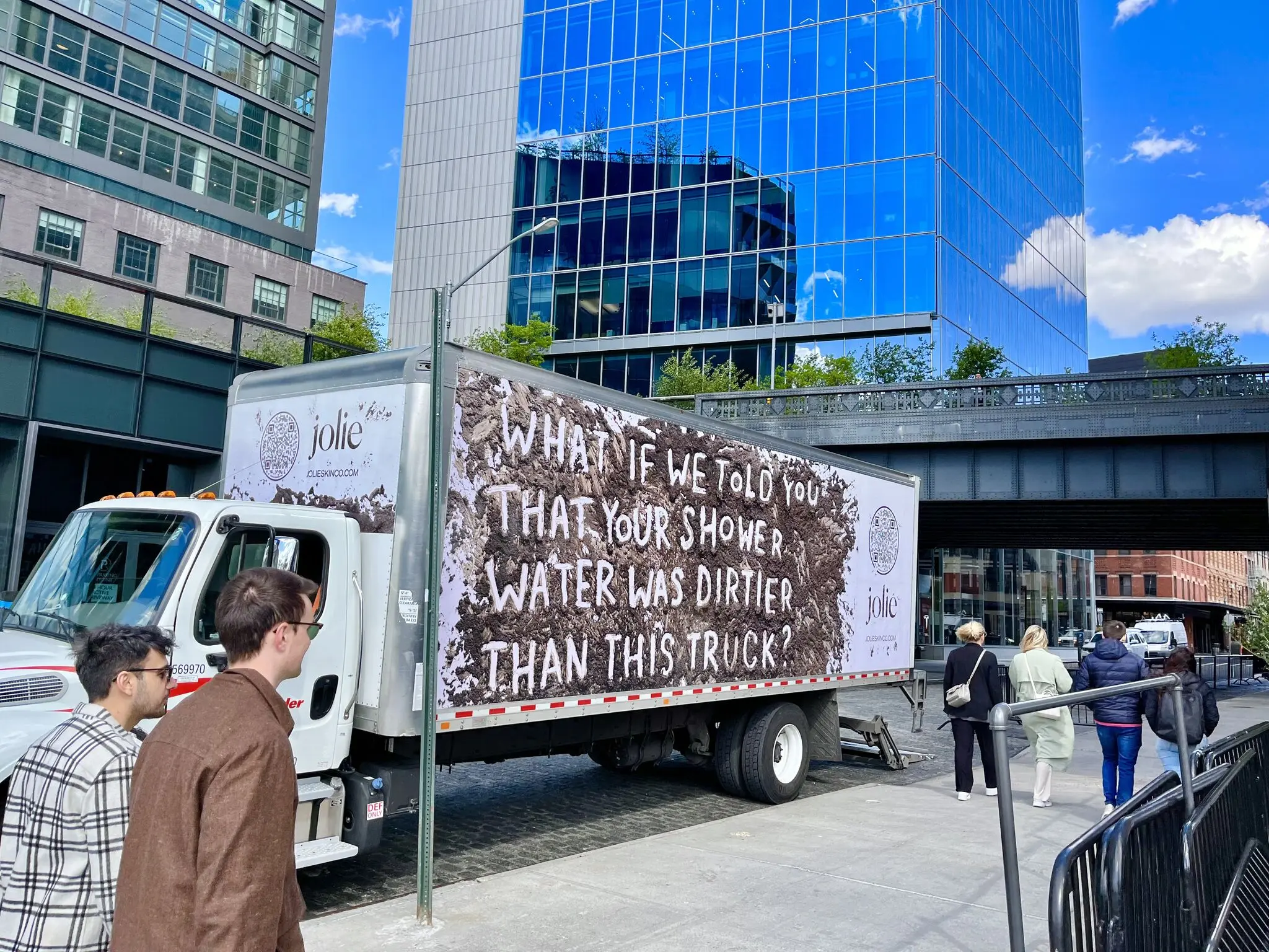 Jolie mobile billboard truck near the High Line in New York showing a mud-textured ad that says What if we told you that your shower water was dirtier than this truck?