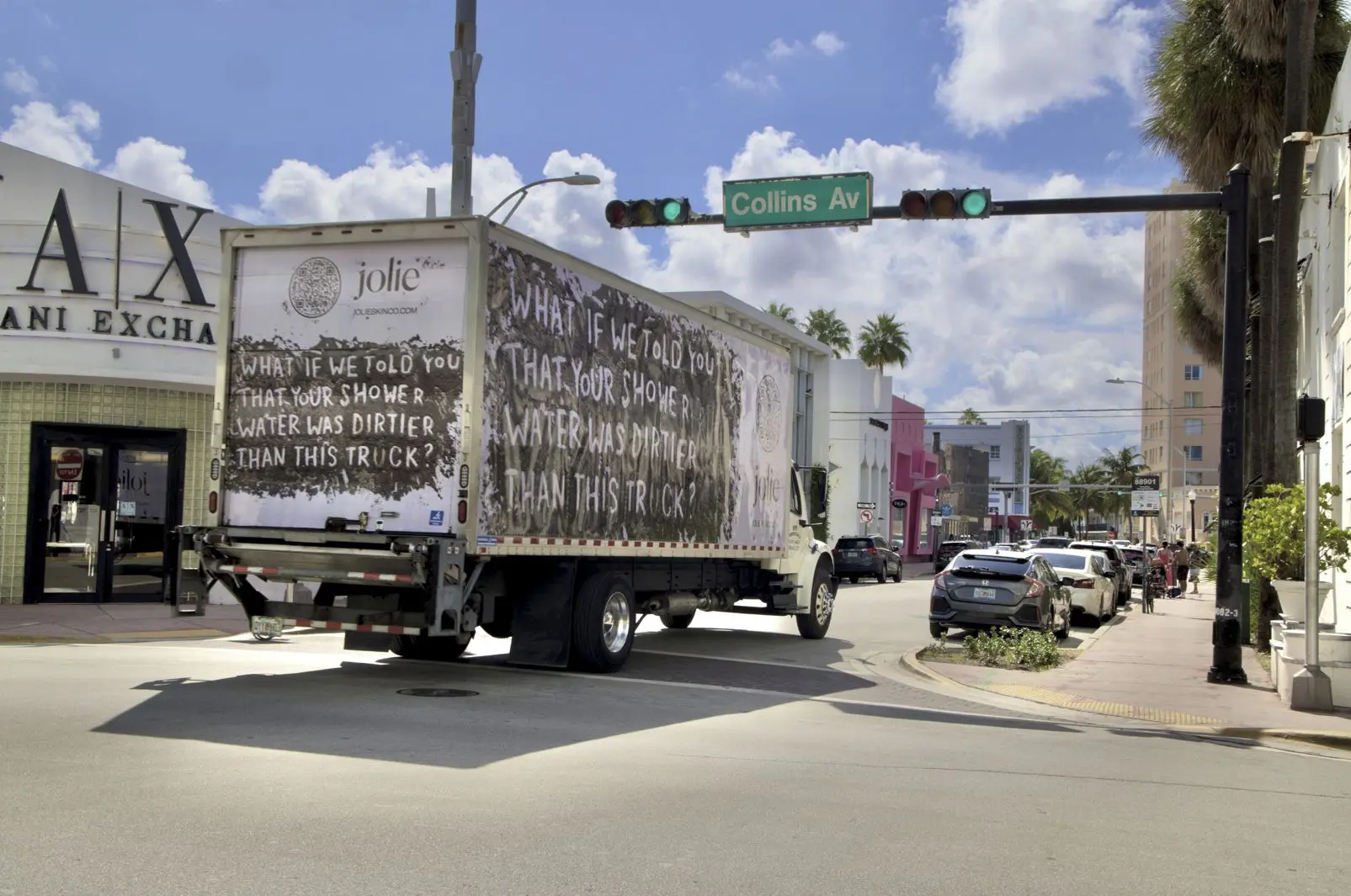 Jolie mobile billboard truck driving on Collins Avenue in Miami Beach with the message What if we told you that your shower water was dirtier than this truck?