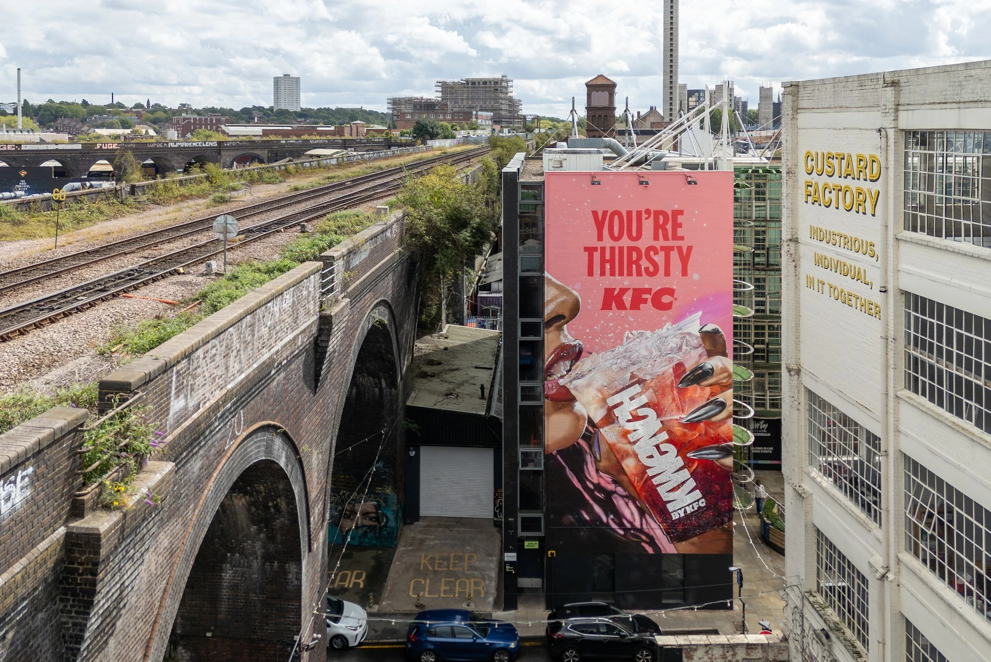 Aerial view of the KFC Kwench mural on the Custard Factory wall in Birmingham featuring a large drink visual and the headline You’re Thirsty KFC.