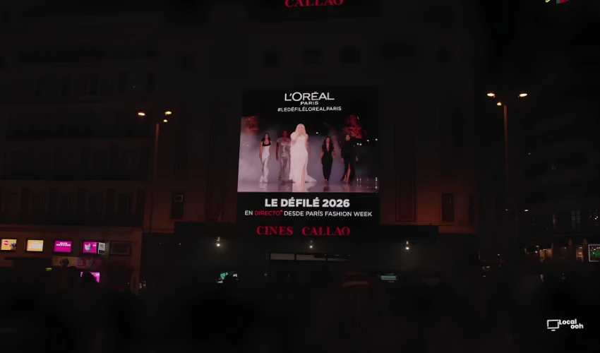 Wide night view of Cines Callao in Madrid with the L’Oréal Paris Le Défilé 2026 live broadcast displayed on the large outdoor digital screen.