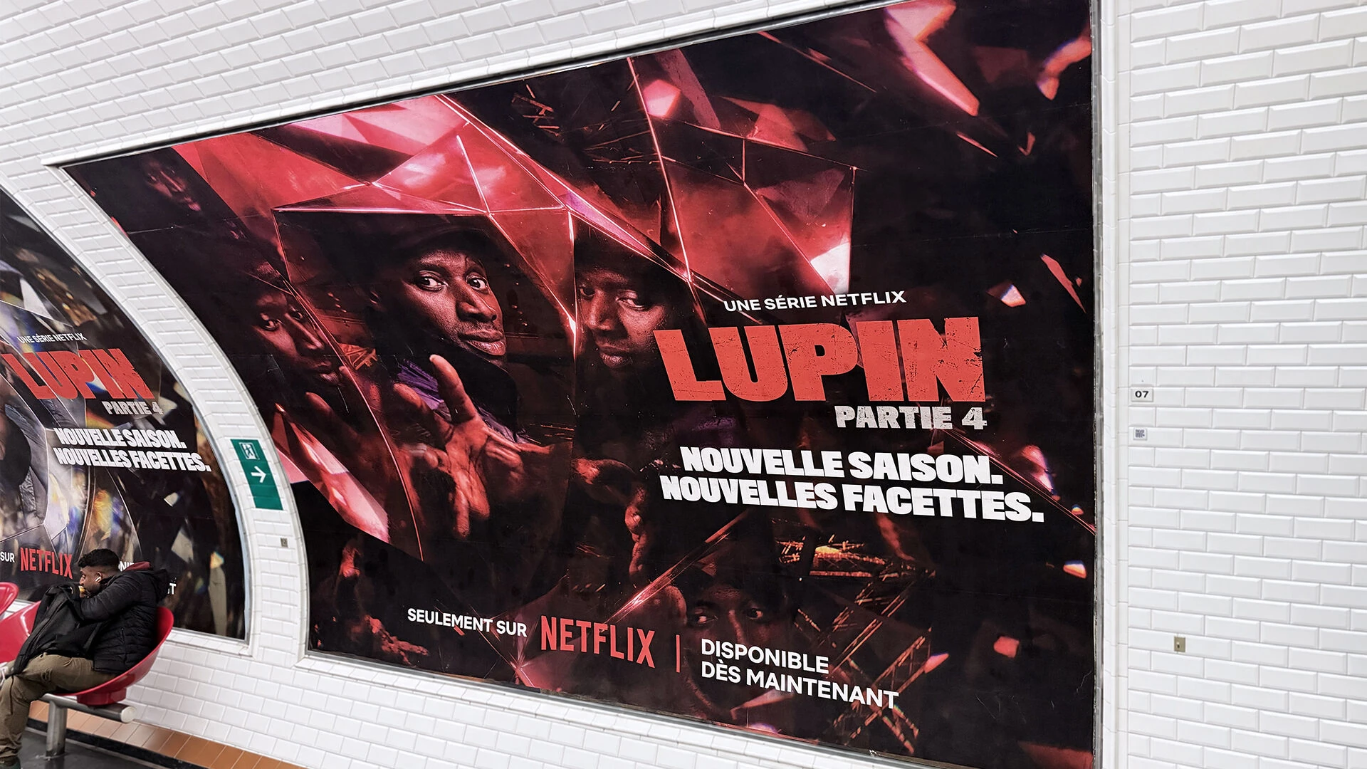 Large Lupin Part 4 Netflix OOH poster inside a Paris Metro station using red gemstone-like reflections and multiple images of Assane Diop.