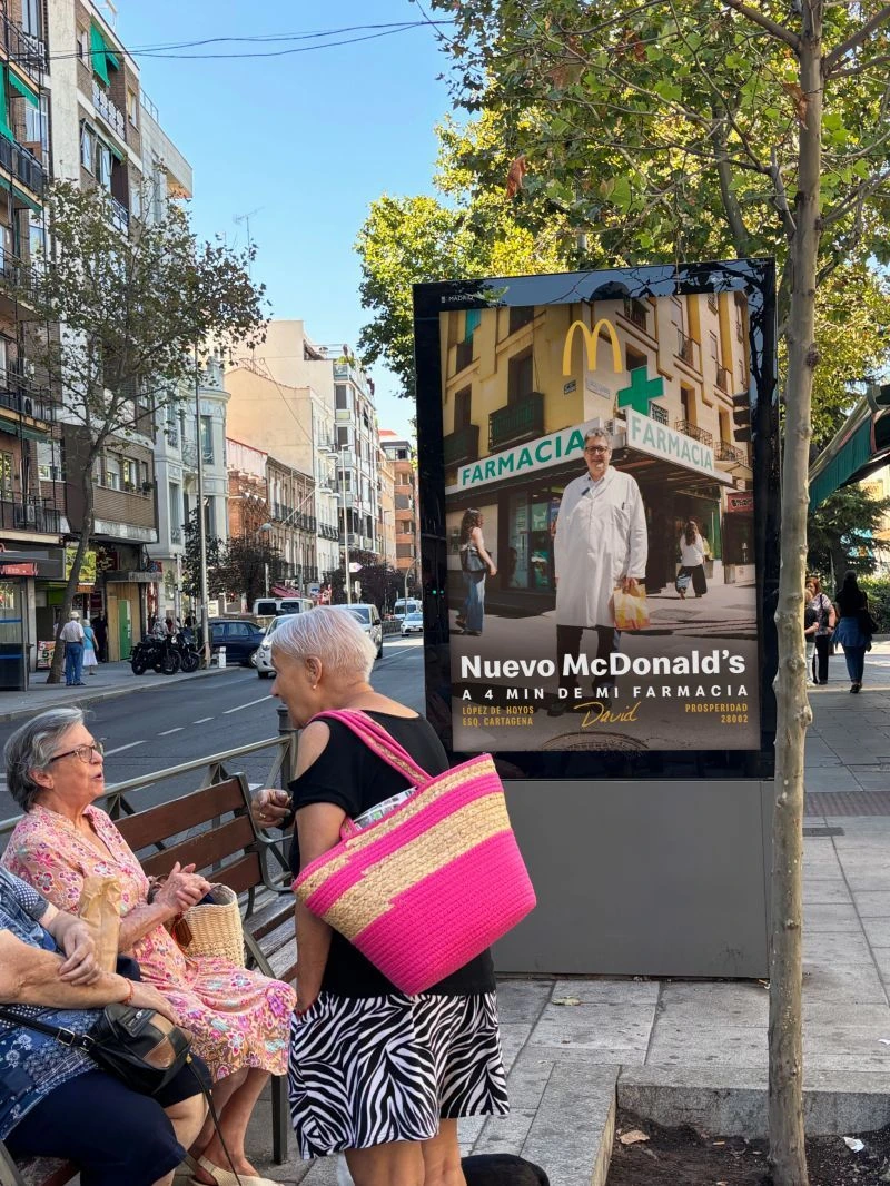 McDonald’s Prosperidad outdoor ad near a pharmacy in Madrid reading Nuevo McDonald’s a 4 min de mi farmacia.