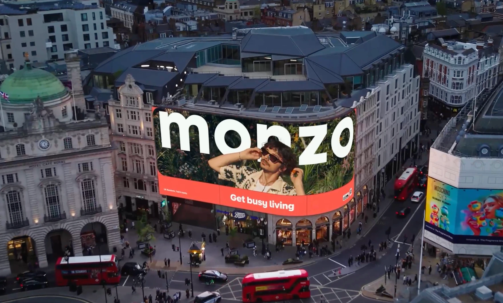 Monzo lifestyle creative on Piccadilly Lights with the Get busy living message.