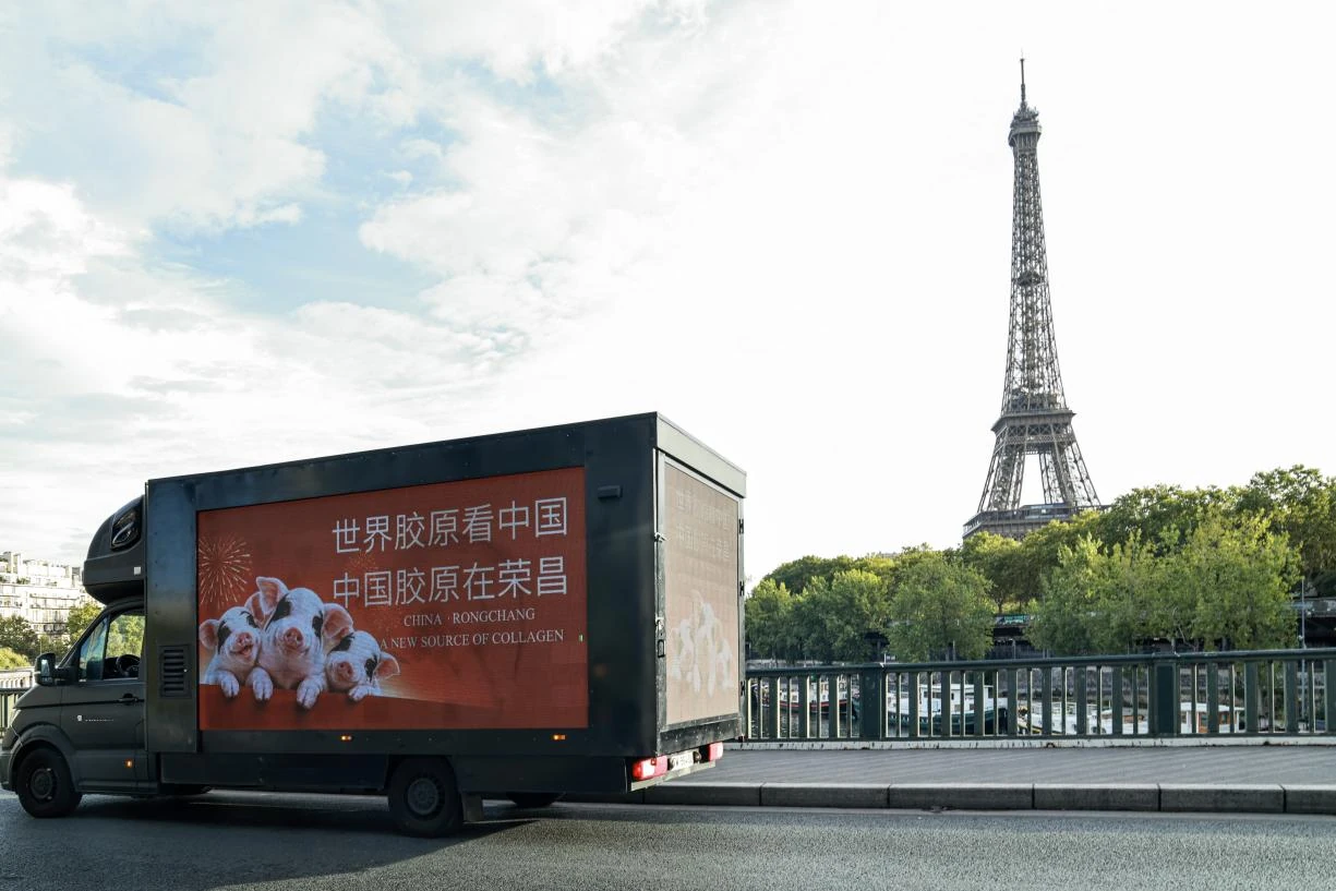 Mobile digital billboard in Paris near the Eiffel Tower promoting Rongchang SPF pigs and China collagen with bilingual Chinese and English creative.