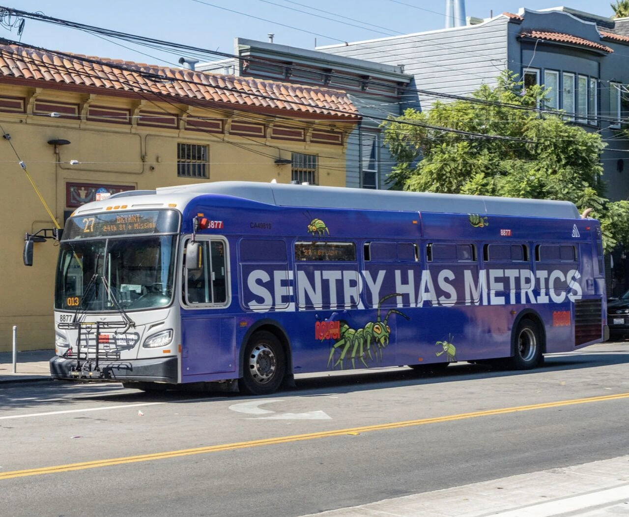 Sentry wrapped SFMTA bus moving through a San Francisco neighborhood with the message Sentry Has Metrics across the side.