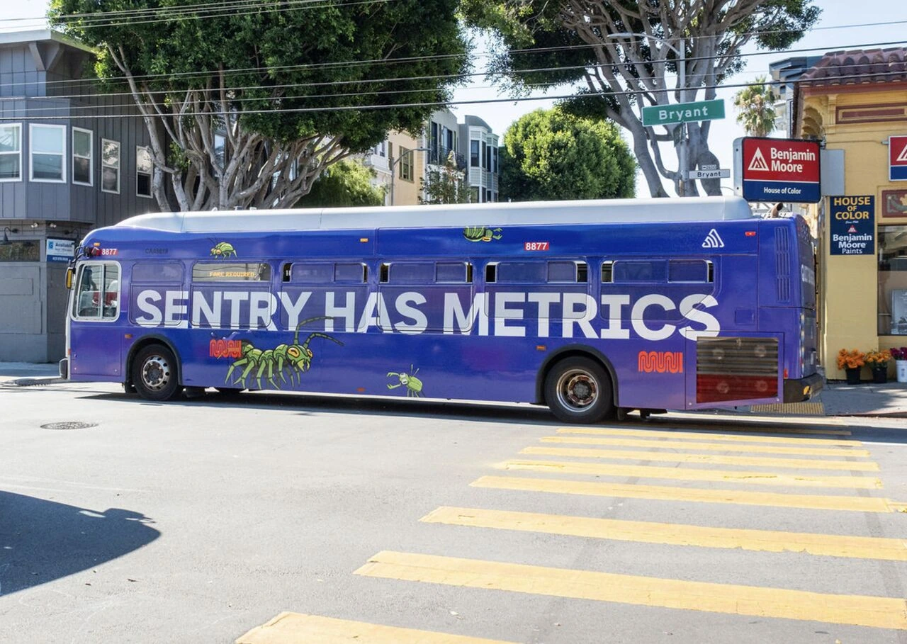 Purple Sentry SFMTA bus wrap in San Francisco displaying the line Sentry Has Metrics with illustrated insect graphics.