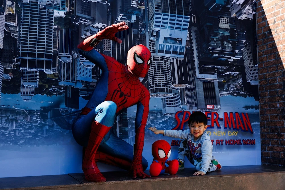 Spider-Man posing with a young fan at the Spider-Man: Brand New Day activation in Sydney.