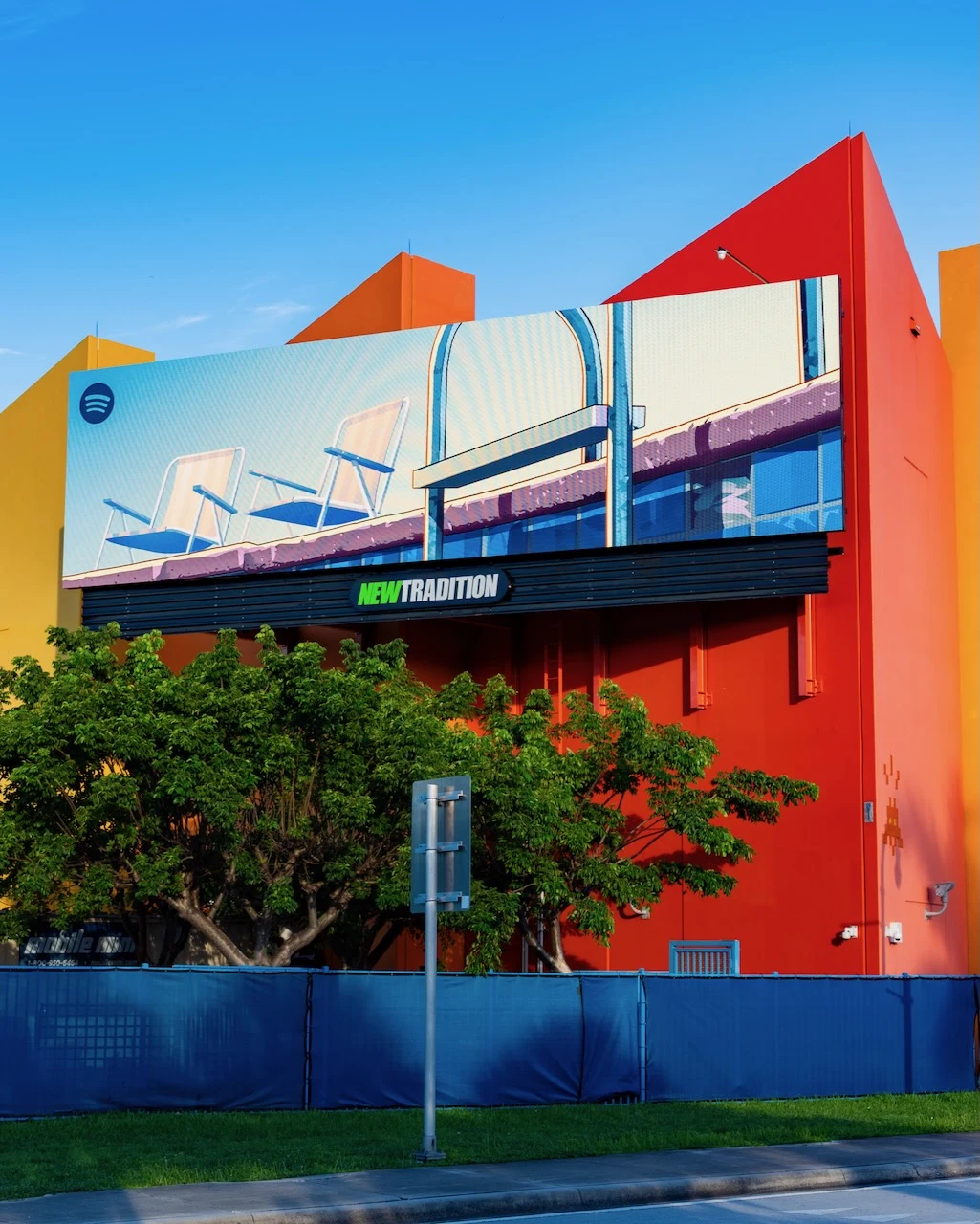 Spotify-branded GTA VI-style digital billboard in Miami showing a colorful rooftop or poolside scene with lounge chairs on a large New Tradition display.