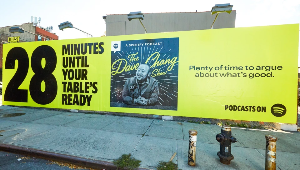 Spotify Podcasts on Spotify wallscape featuring The Dave Chang Show and the line 28 minutes until your table’s ready.