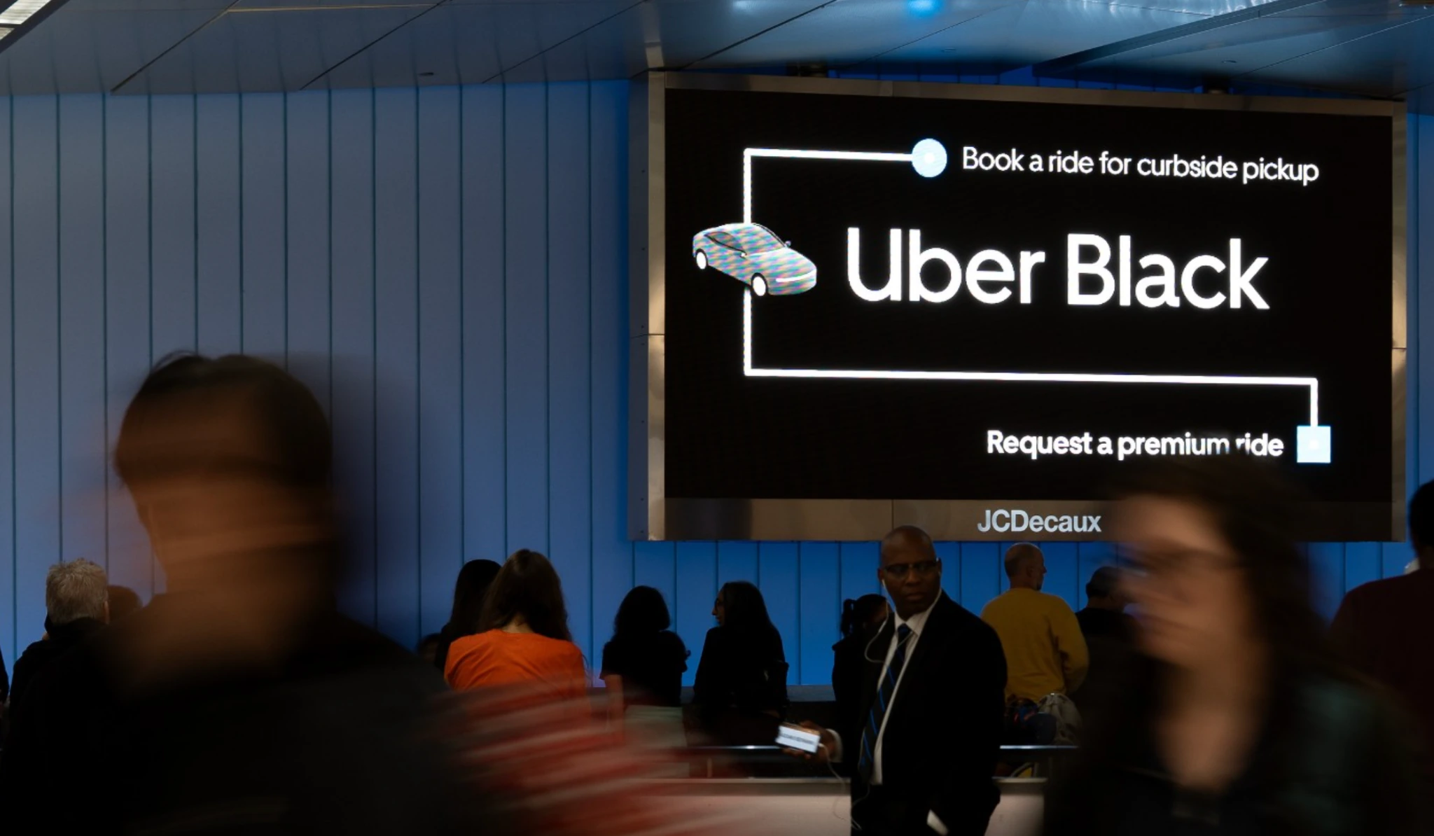Uber Black digital airport billboard reading Book a ride for curbside pickup and Request a premium ride.