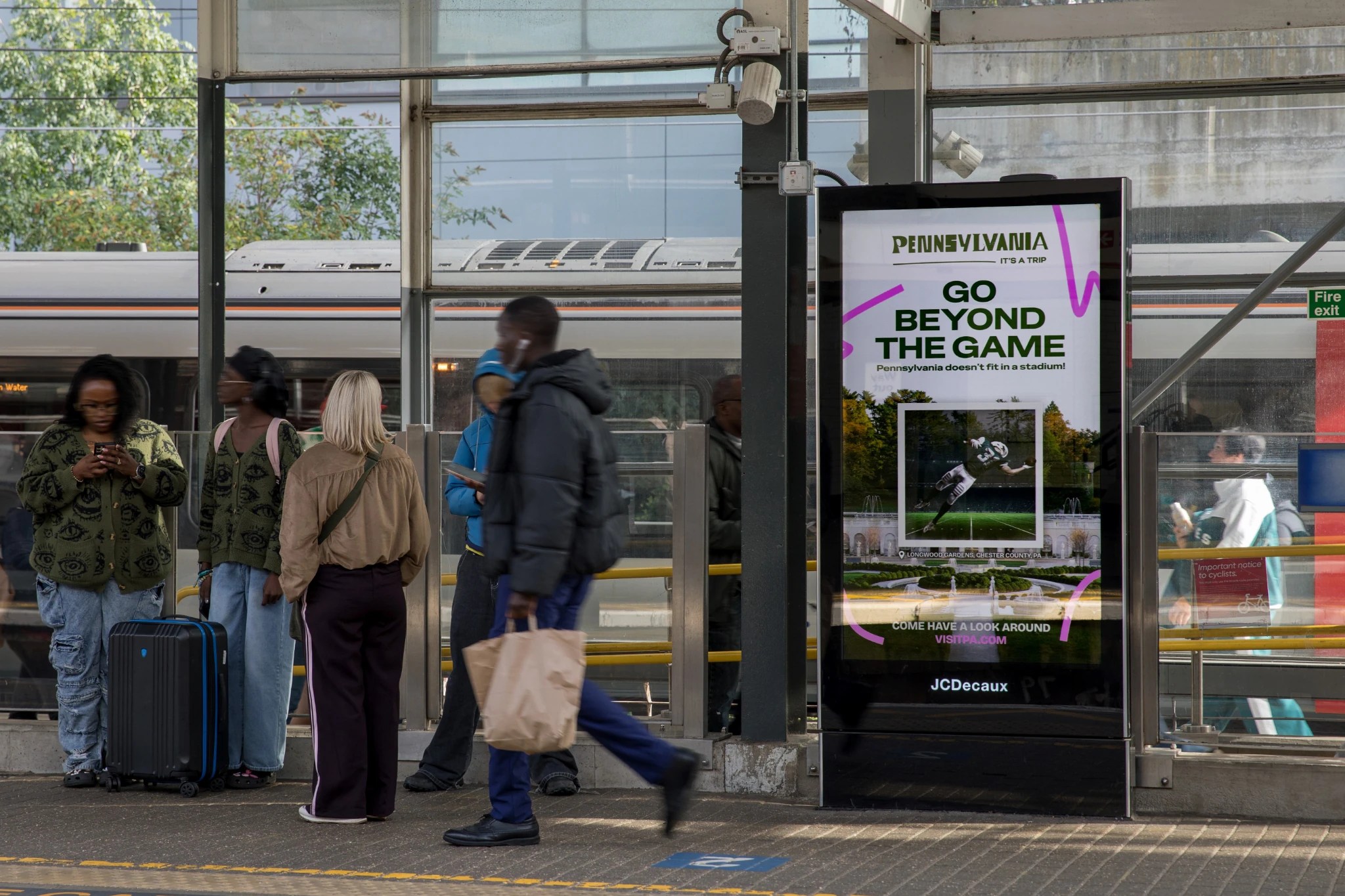 Visit Pennsylvania digital kiosk in London displaying the Go Beyond the Game tourism campaign with American football imagery and Pennsylvania destination visuals.