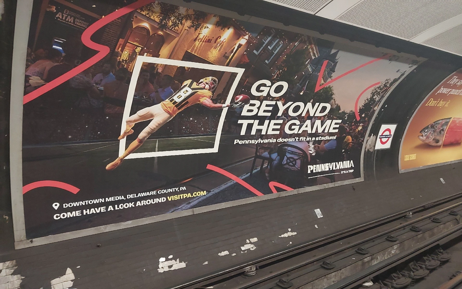 Visit Pennsylvania OOH advertisement inside the London Underground featuring an American football player and the line Go Beyond the Game.