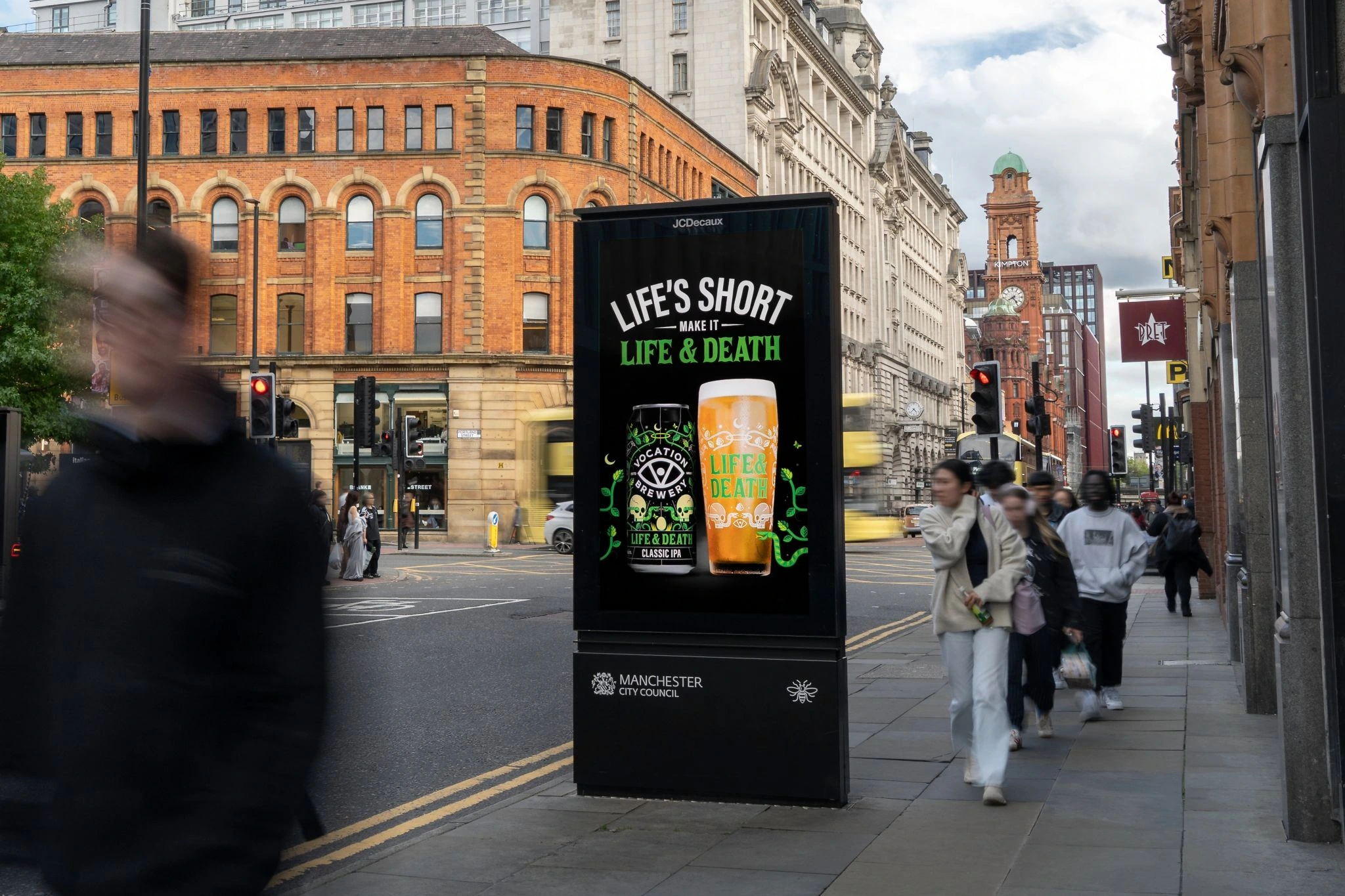 Autumn OOH display for Vocation Brewery Life & Death IPA on a city sidewalk surrounded by pedestrians and buildings.