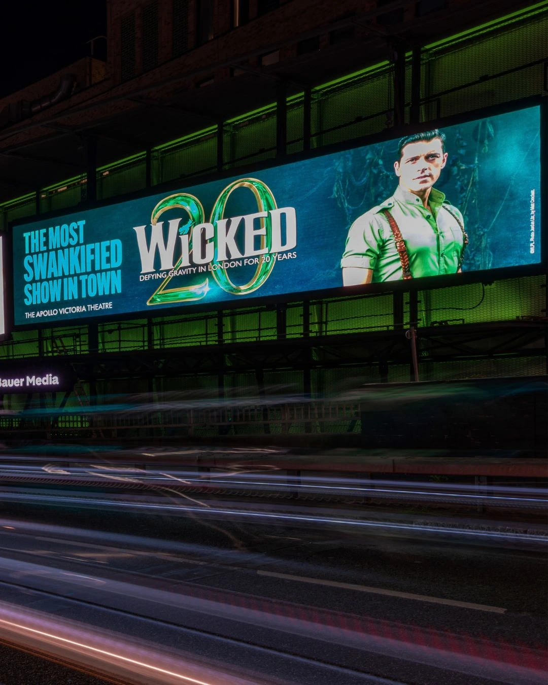 Wicked 20 years billboard in London featuring Fiyero and the line The most swankified show in town.